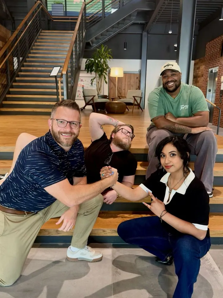 The Genius team posing on office stairs